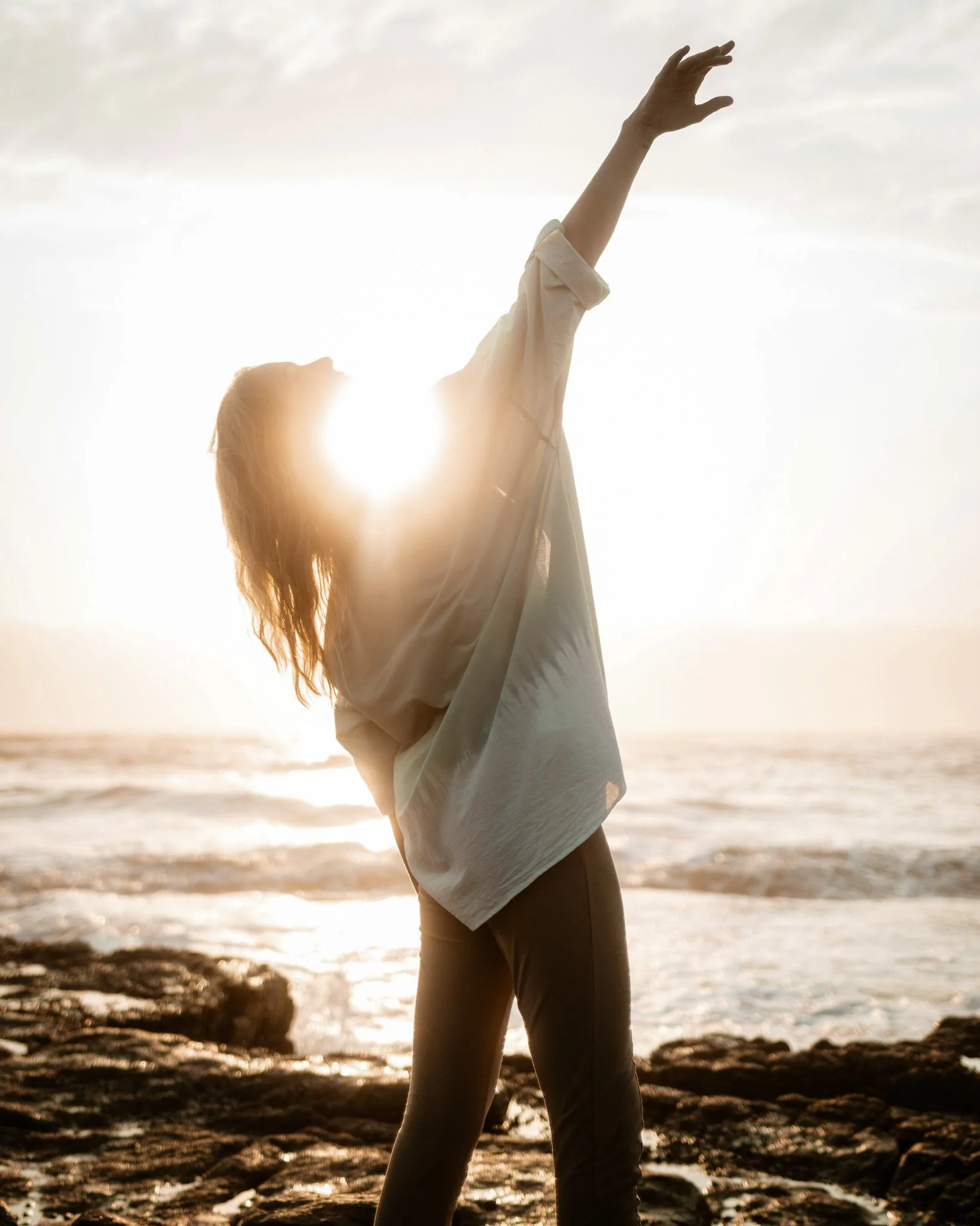 A person opens their arms to the light