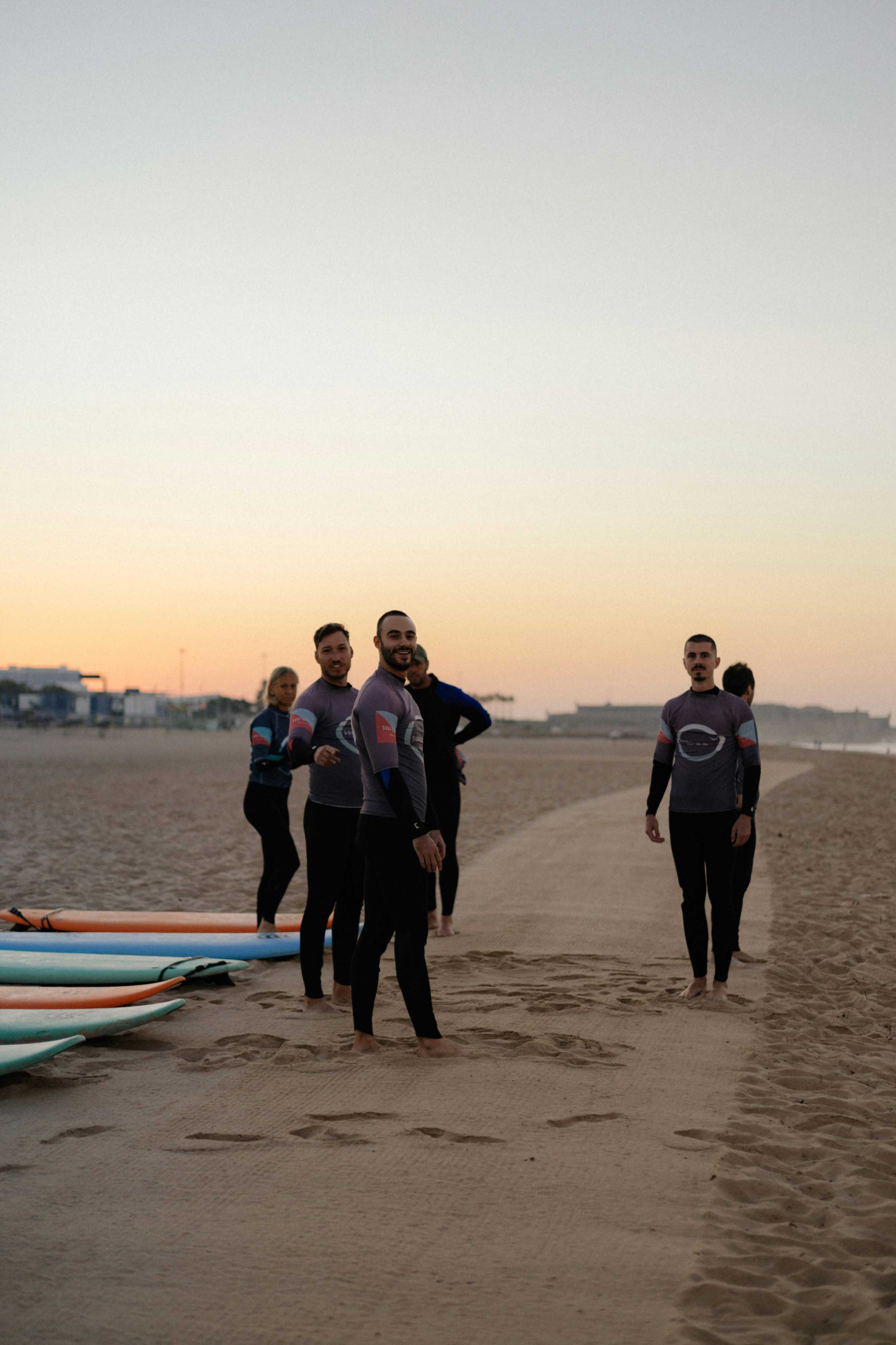 A group preparing to surf together on a beach in the Basque Country