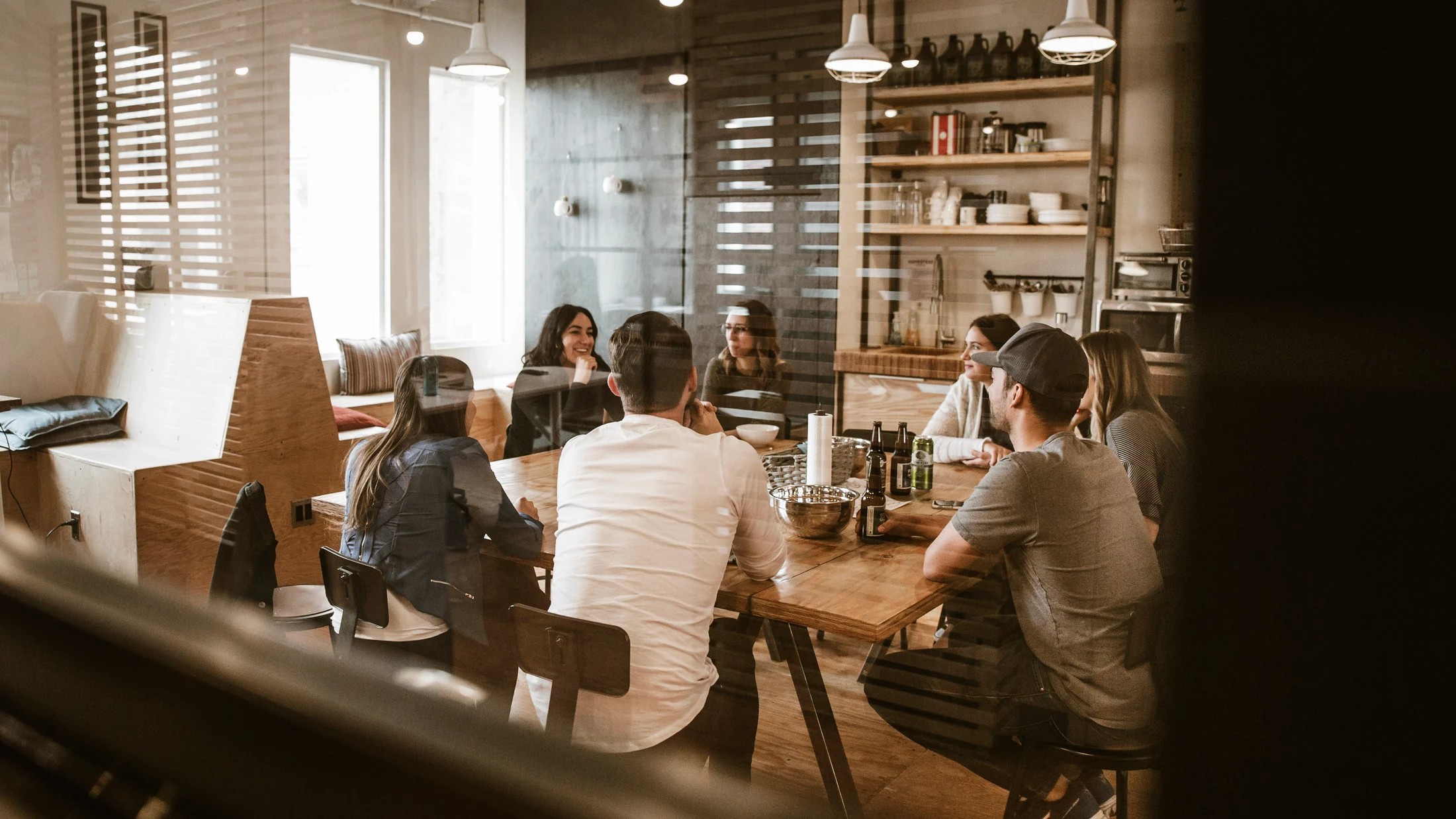 A team meets around a table in a bright workspace