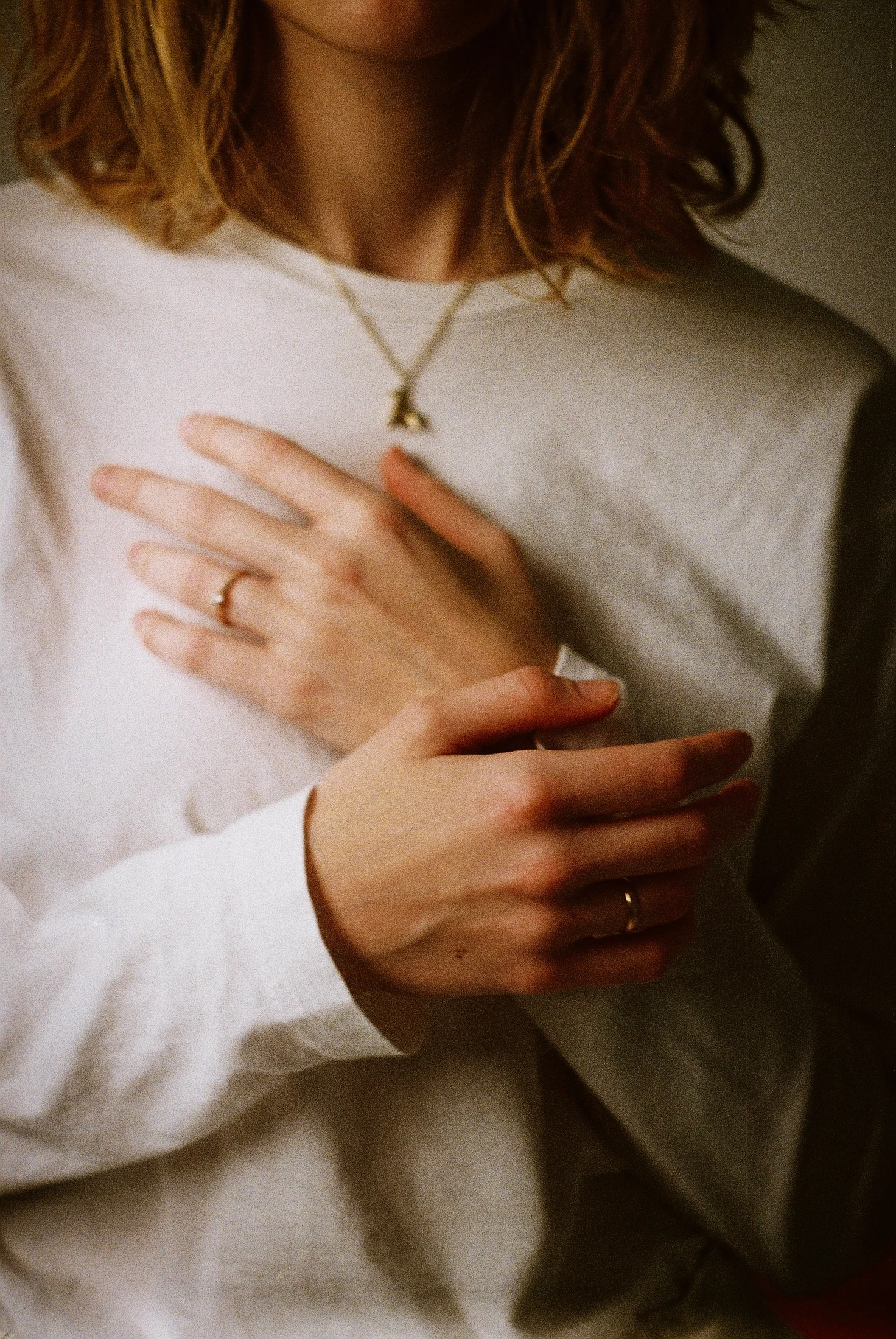 Une personne pose les mains sur son cœur, dans un geste de présence corporelle